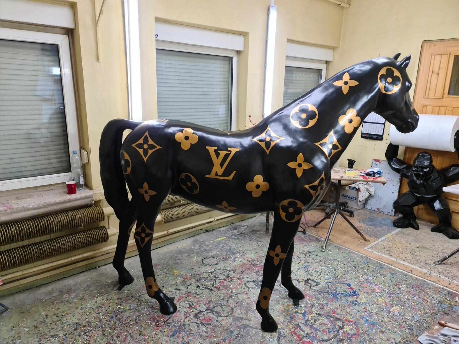 Abstract designer garden sculpture of black horse with LV style patterns figure