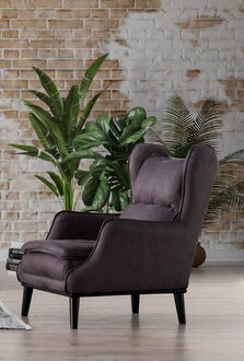 Elegant dark purple armchair with ottoman for a stylish living environment.