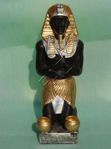 Black gold colored decor figure of an ancient egyptian pharaoh with two golden cups