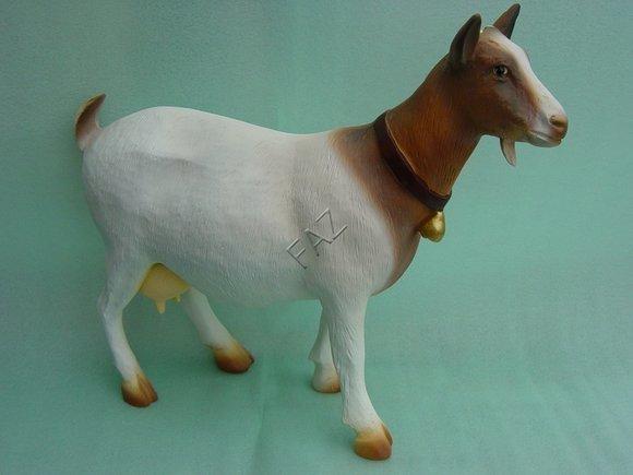 Decorative sculpture designed as motley brown white colored goat with a ring 45x51x18cm