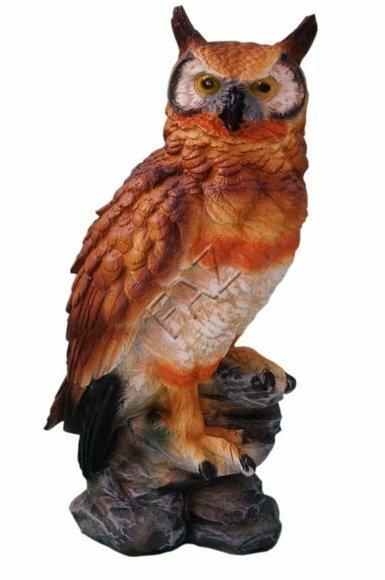 Decorative sculpture designed as motley brown colored owl with hazel eyes